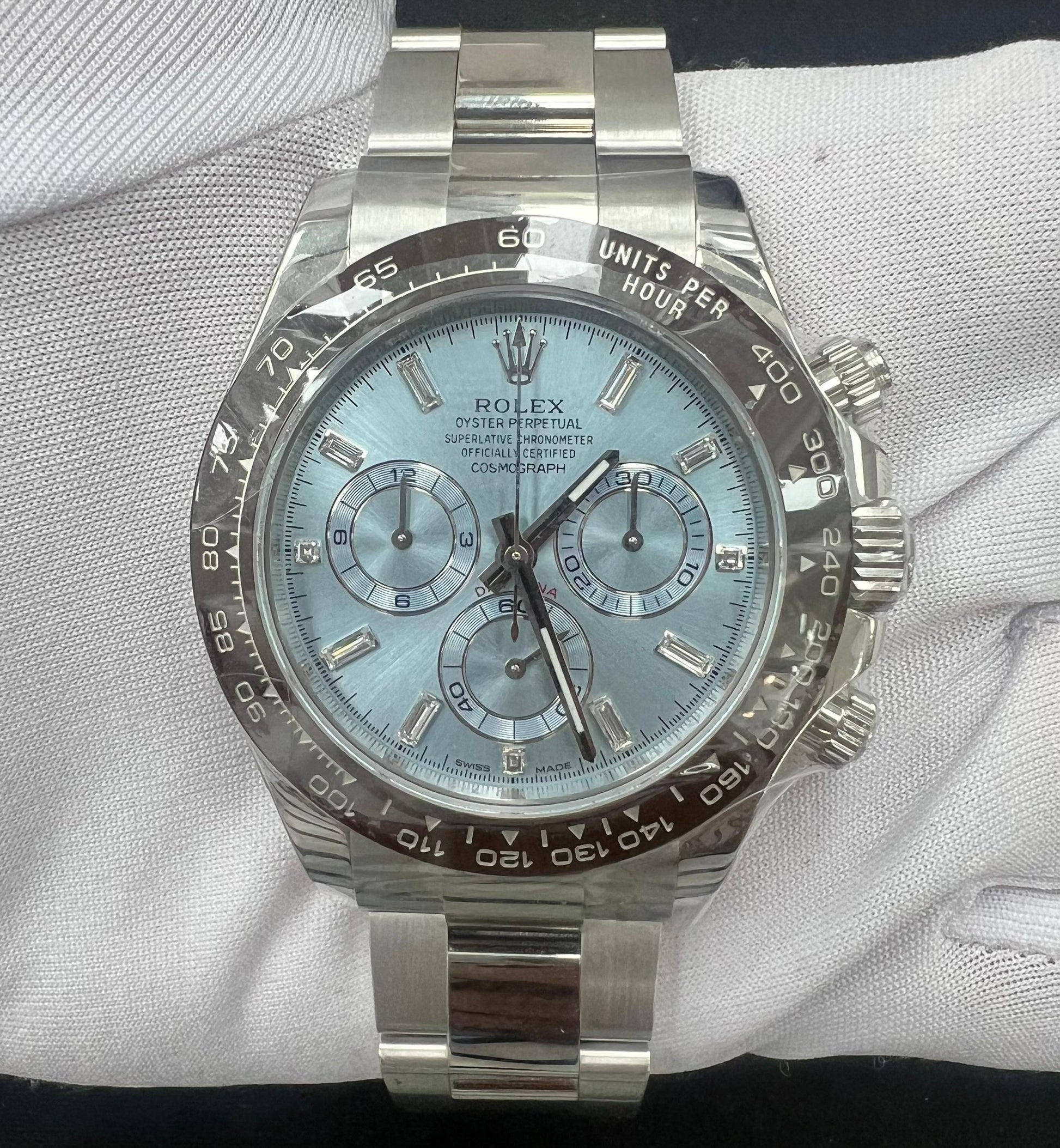Platinum Rolex watch with a light blue face on a white gloved hand