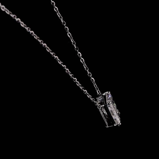 White gold necklace with an "E" shaped diamond letter pendant rotating from various angles over a dark background