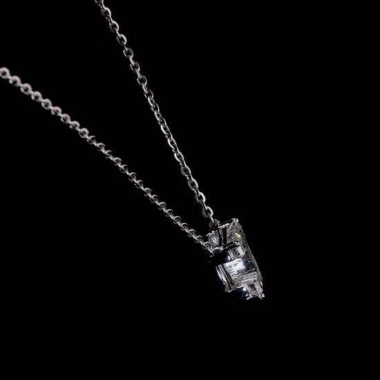 White gold necklace with a "J" shaped diamond letter pendant rotating from various angles over a dark background