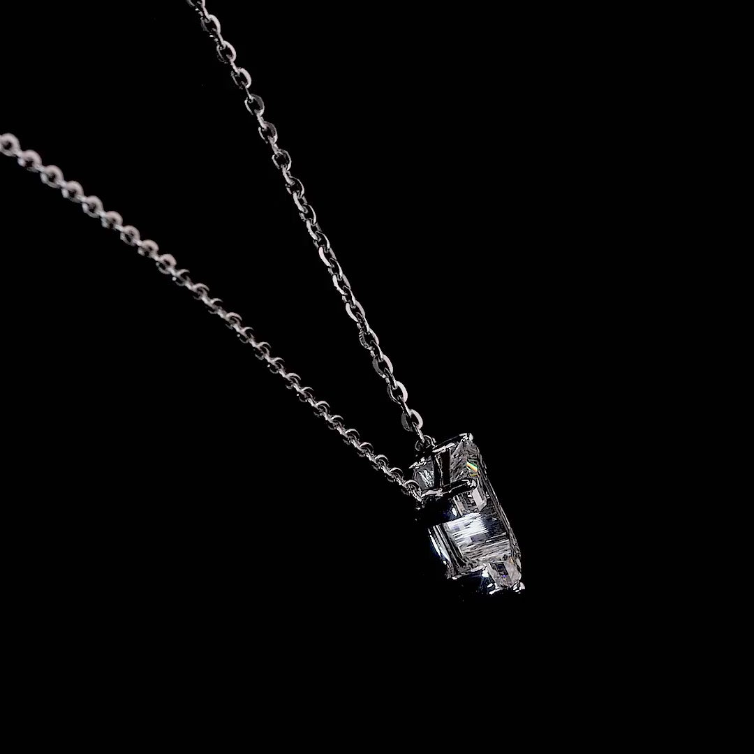 White gold necklace with a "J" shaped diamond letter pendant rotating from various angles over a dark background