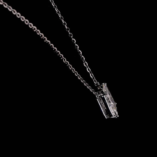 White gold necklace with an "M" shaped diamond letter pendant rotating from various angles over a dark background