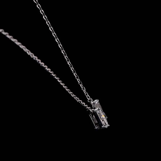 White gold necklace with a "K" shaped diamond letter pendant rotating from various angles over a dark background