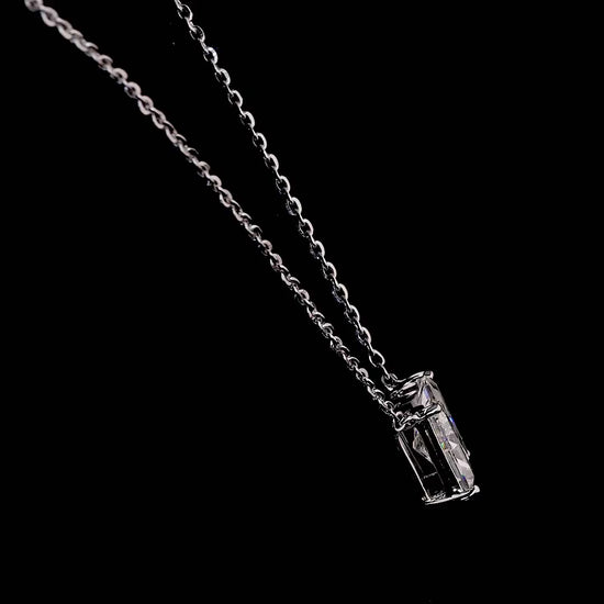 White gold necklace with an "N" shaped diamond letter pendant rotating from various angles over a dark background