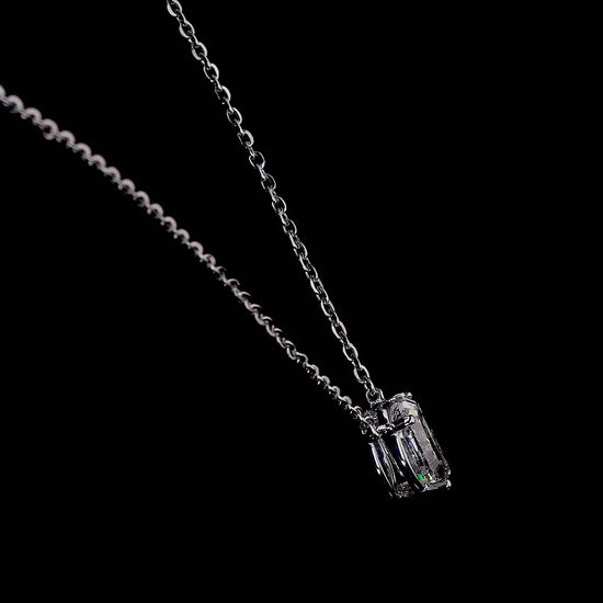 Video of a white gold necklace with a "Q" shaped diamond letter pendant rotating from various angles over a dark background