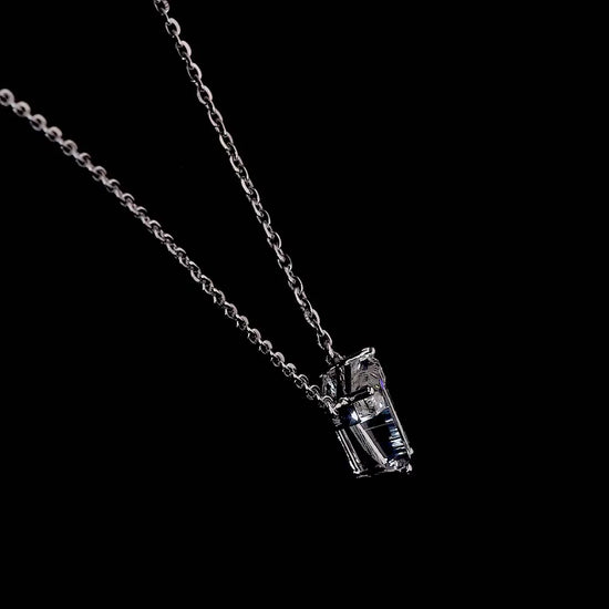 White gold necklace with a "T" shaped diamond letter pendant rotating from various angles over a dark background