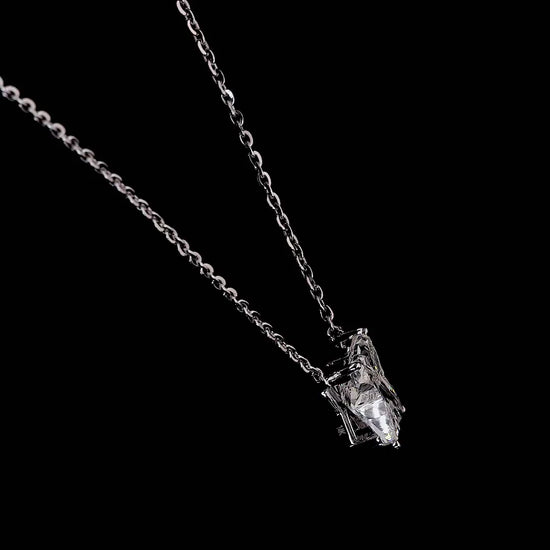 White gold necklace with an "X" shaped diamond letter pendant rotating from various angles over a dark background